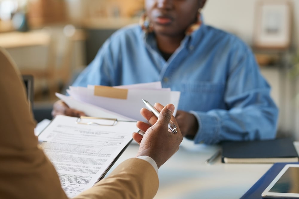 Person reviewing IRS tax documents with an advisor during negotiation