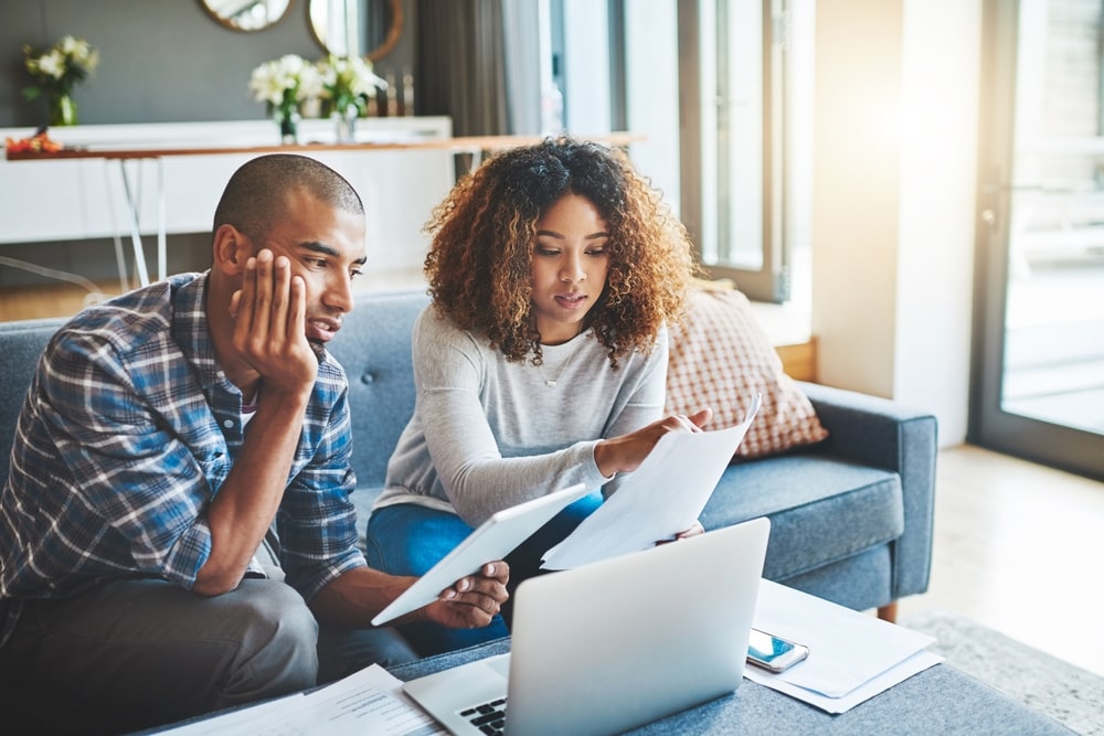 A couple reviewing IRS tax documents on a laptop at home