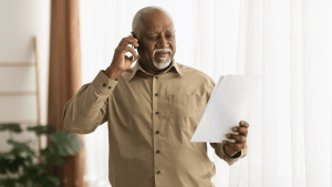 A man holds a document titled “My Tax Debt Plan” while reviewing IRS payment and relief options.