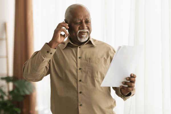 A man holds a document titled “My Tax Debt Plan” while reviewing IRS payment and relief options.