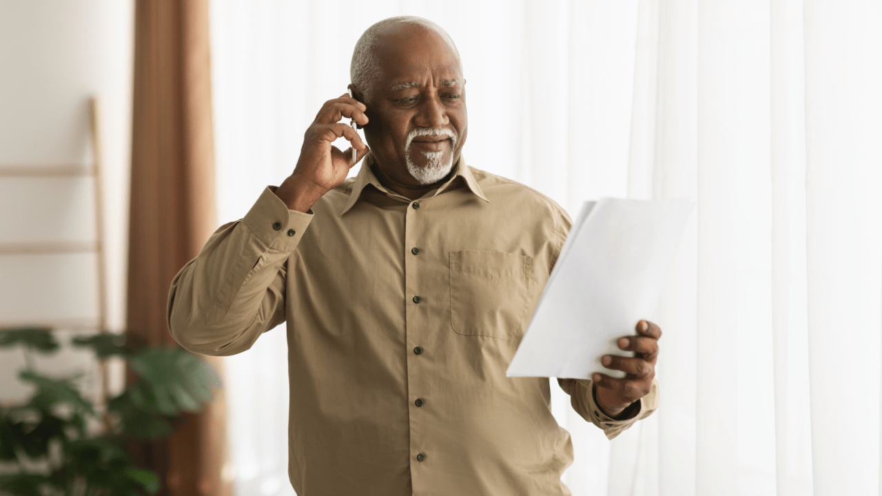A man holds a document titled “My Tax Debt Plan” while reviewing IRS payment and relief options.