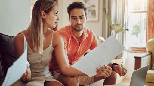 Young couple reviewing tax documents at home wondering does IRS debt ever expire