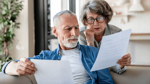A senior couple is reviewing financial documents, wondering does IRS debt get passed down to heirs