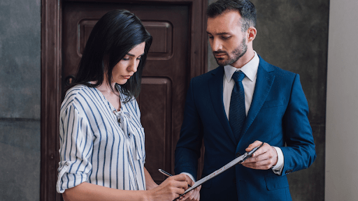 Woman signing documents with professional man in suit representing does IRS use debt collectors scenario