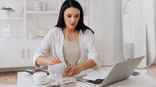 Young woman calculating taxes at laptop researching IRS debt forgiveness 2023 programs and options