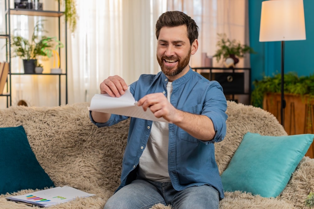 Happy man tearing financial documents after resolving IRS debt
