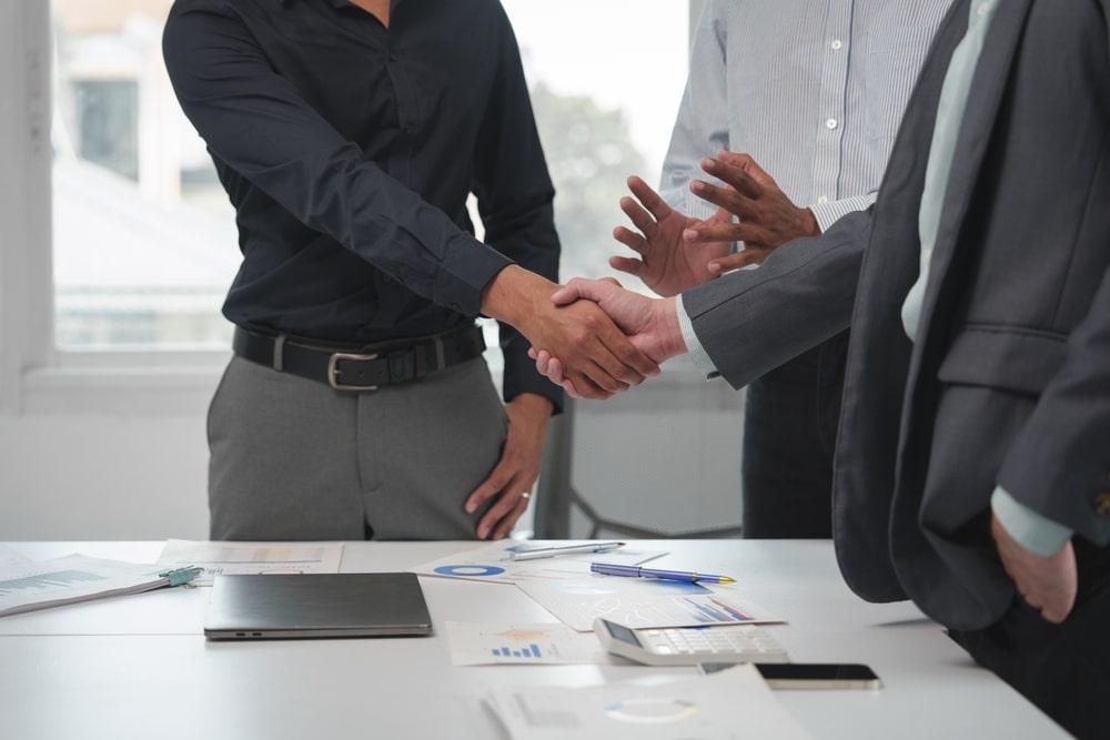 Business professionals shaking hands after negotiating tax debt settlement