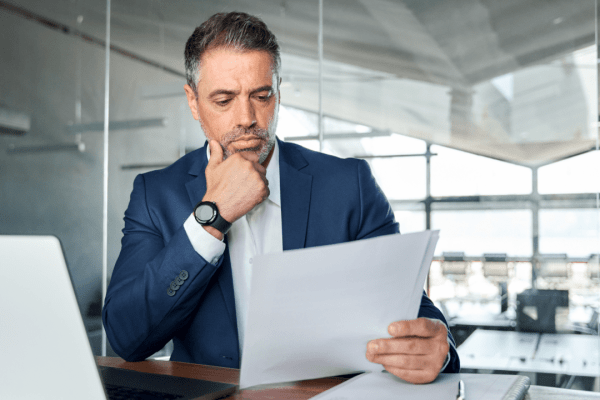 Business professional reviewing bankruptcy documents wondering can IRS debt be included in Chapter 13 filing