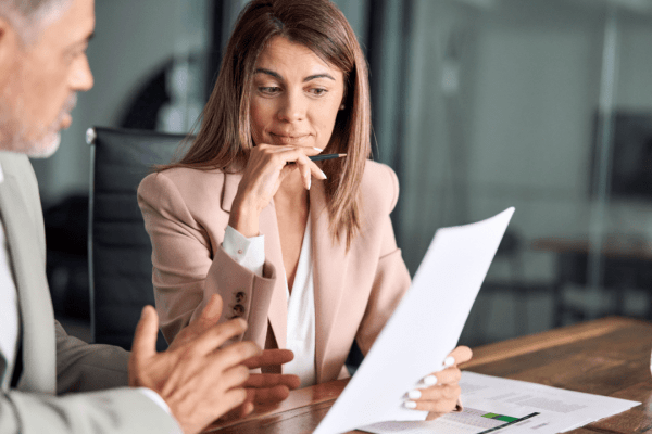 Woman reviewing bankruptcy documents with an attorney discussing IRS debt and Chapter 7 filing options