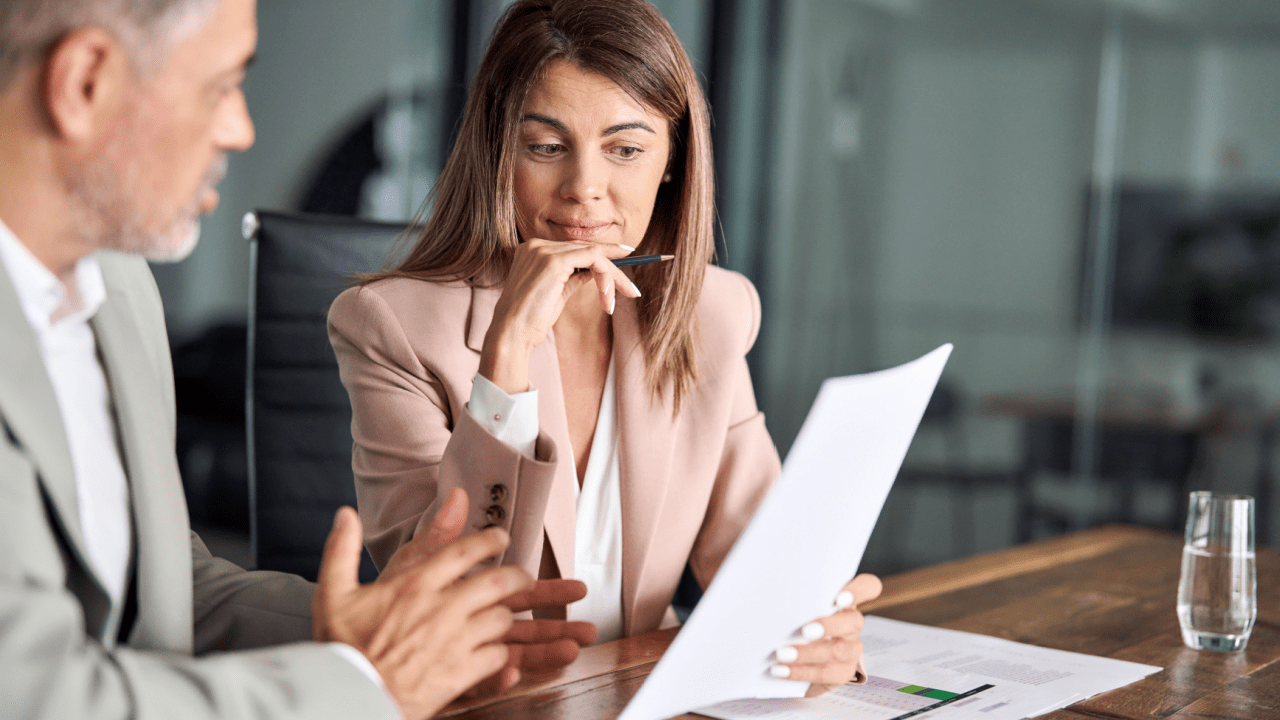 Woman reviewing bankruptcy documents with an attorney discussing IRS debt and Chapter 7 filing options