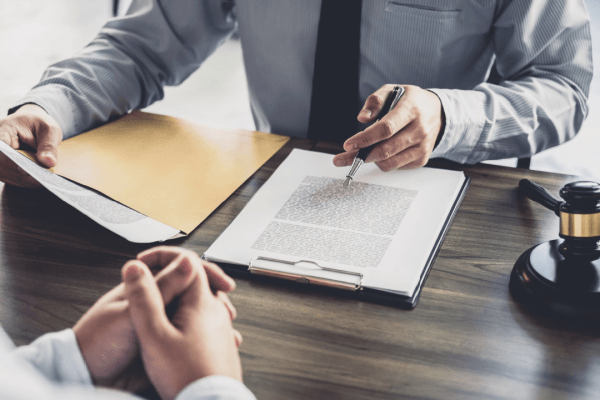 Attorney reviewing legal documents about tax deduction for bad debt with client consultation and gavel