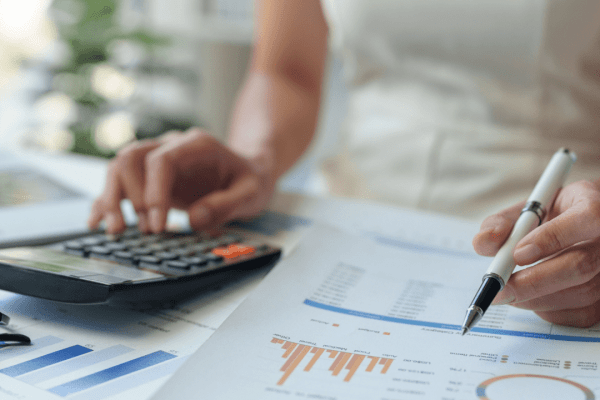 Person calculating 0 debt to income ratio using calculator while reviewing financial charts and debt analysis documents