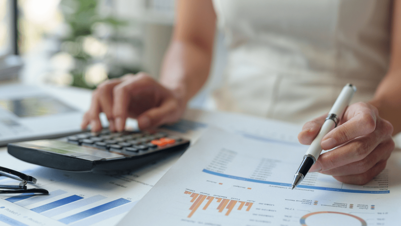Person calculating 0 debt to income ratio using calculator while reviewing financial charts and debt analysis documents