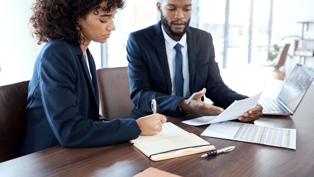 Tax professionals reviewing 0 tax owed debt relief program documentation while client takes notes during consultation meeting