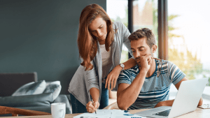 Worried couple researching does tax debt get passed down while reviewing estate planning and tax documents at home