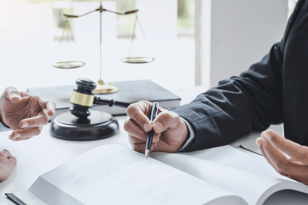 Attorney consulting with client about does tax debt go on your credit report during legal meeting with scales of justice and gavel