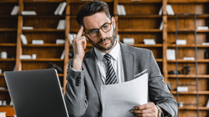 Professional tax attorney reviewing IRS debt cancellation form documents while researching tax relief options in law library