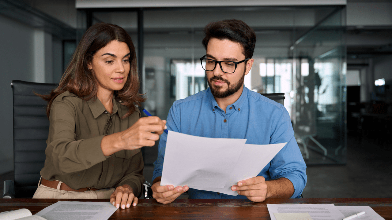 Tax advisor explaining IRS debt uncollectible status application to client while reviewing financial hardship documentation in modern office