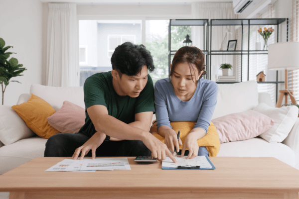 Divorced couple discussing IRS debt after divorce settlement using calculator and financial documents