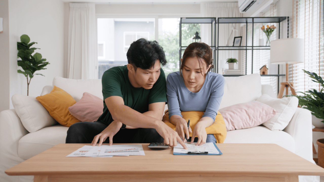 Divorced couple discussing IRS debt after divorce settlement using calculator and financial documents