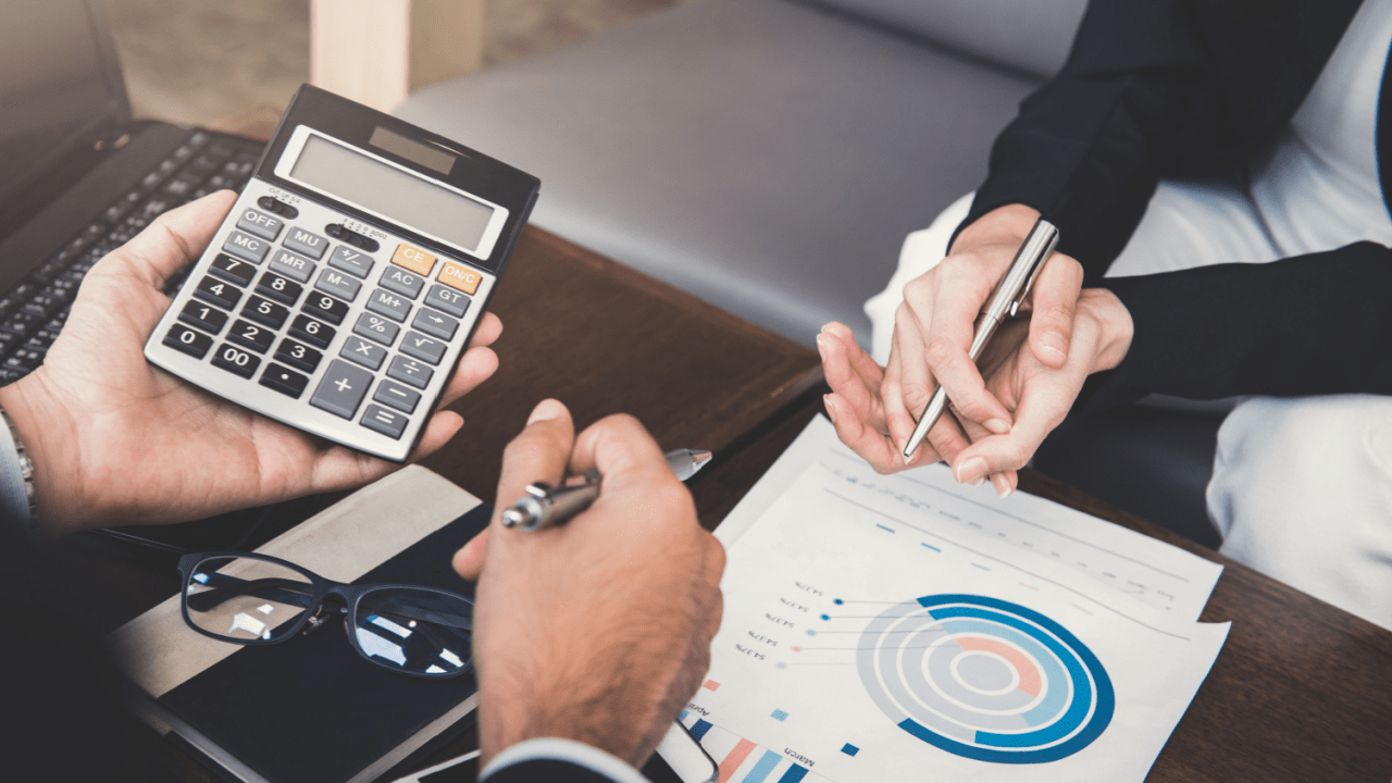 Business professionals calculating tax debt after 10 years statute limitations using calculator while reviewing financial charts and data