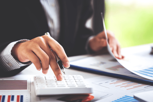 Professional calculating tax debt solutions with calculator and financial documents showing the best way to deal with tax debt