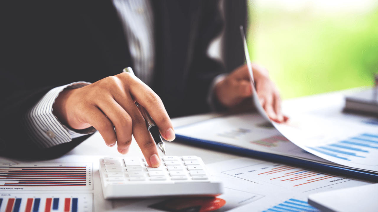 Professional calculating tax debt solutions with calculator and financial documents showing the best way to deal with tax debt