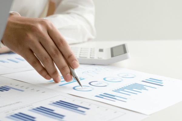 Person analyzing financial charts and using calculator while researching can I negotiate with the IRS myself for tax debt resolution