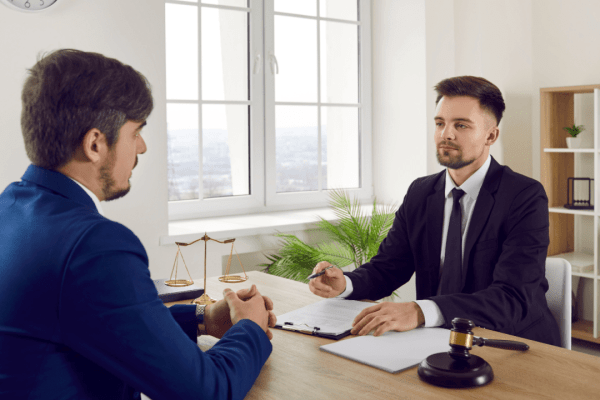 Bankruptcy attorney consulting with client about can IRS debt be included in Chapter 7 bankruptcy proceedings in professional law office
