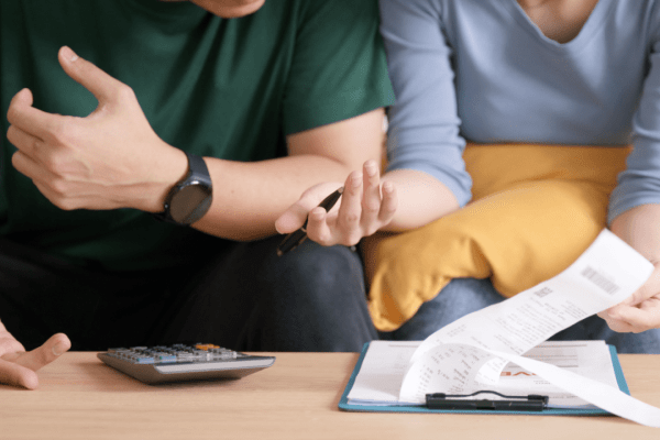 Couple discussing IRS tax relief program options with financial documents and calculator on table