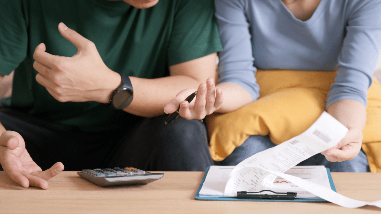 Couple discussing IRS tax relief program options with financial documents and calculator on table