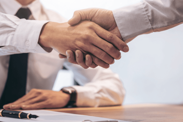 Professional handshake between tax attorney and client discussing how to get help with tax debt relief options