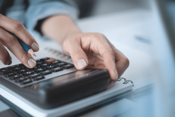Tax professional calculating IRS debt forgiveness options on calculator with financial documents