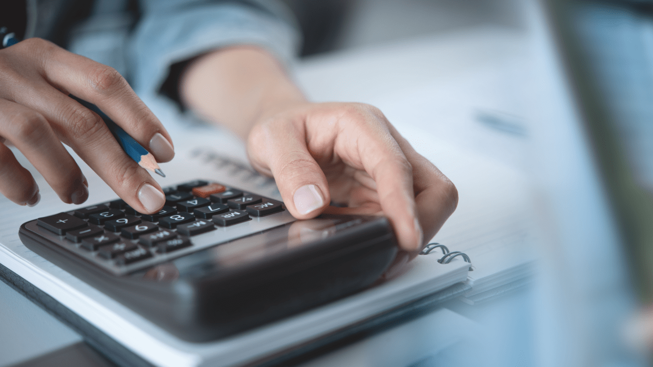 Tax professional calculating IRS debt forgiveness options on calculator with financial documents