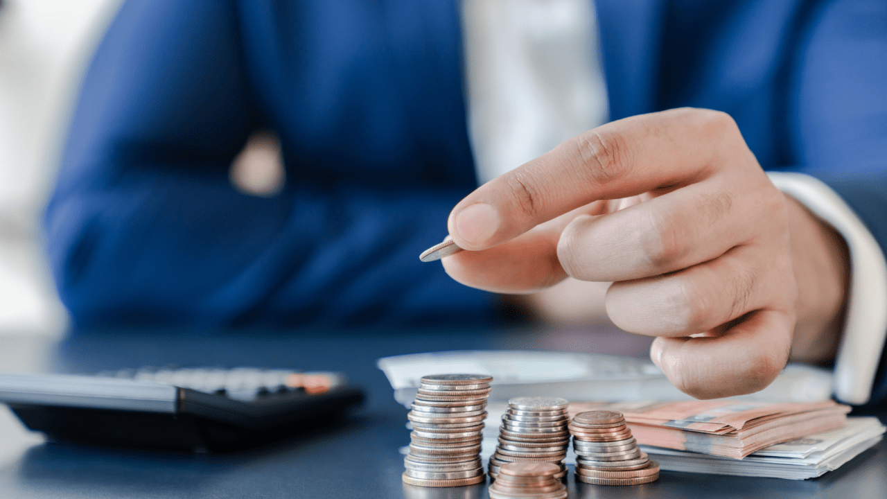Business professional arranging coins to demonstrate tax debt installment plan payment structure with calculator and cash