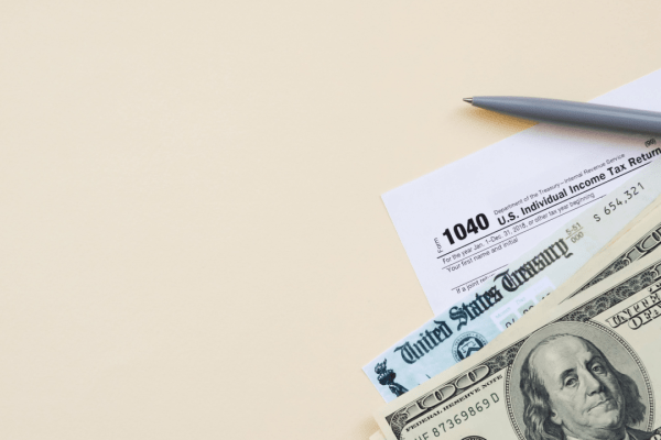 What happens if you owe the IRS more than $25,000 - tax forms, stimulus check, and cash on desk