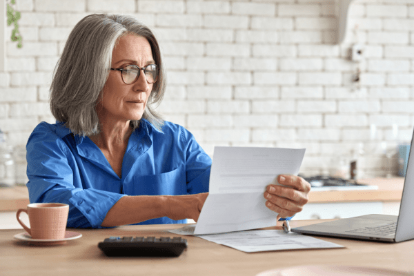 Woman reviewing tax documents to determine what is considered a hardship for tax debt relief