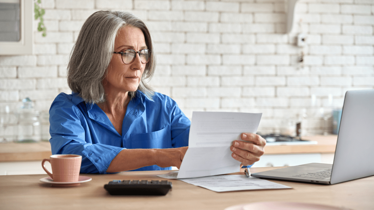 Woman reviewing tax documents to determine what is considered a hardship for tax debt relief