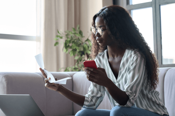 Woman researching what is the IRS one-time forgiveness program on laptop with tax documents