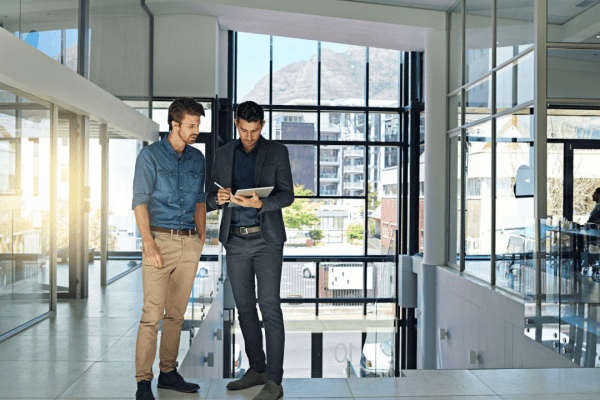 Two professional tax attorneys discussing client cases in modern office building, illustrating are tax attorneys worth it for complex financial matters