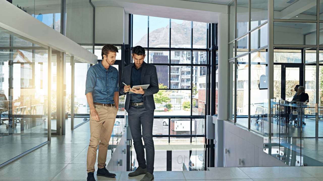 Two professional tax attorneys discussing client cases in modern office building, illustrating are tax attorneys worth it for complex financial matters