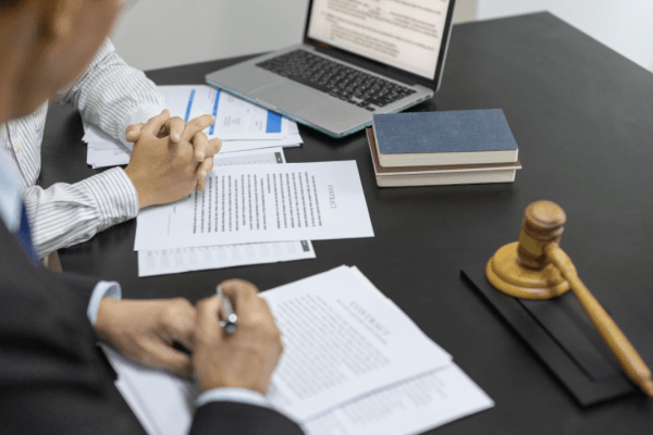 CPA meeting with client at desk with legal documents and gavel showing can a CPA help with IRS problems consultation