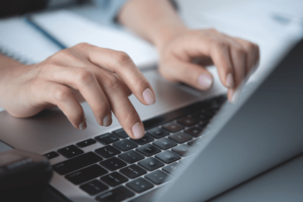 Person typing on laptop researching do I need a lawyer for back taxes online