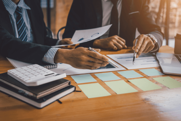 Tax professionals reviewing financial documents and charts showing how to get IRS to forgive tax debt strategies