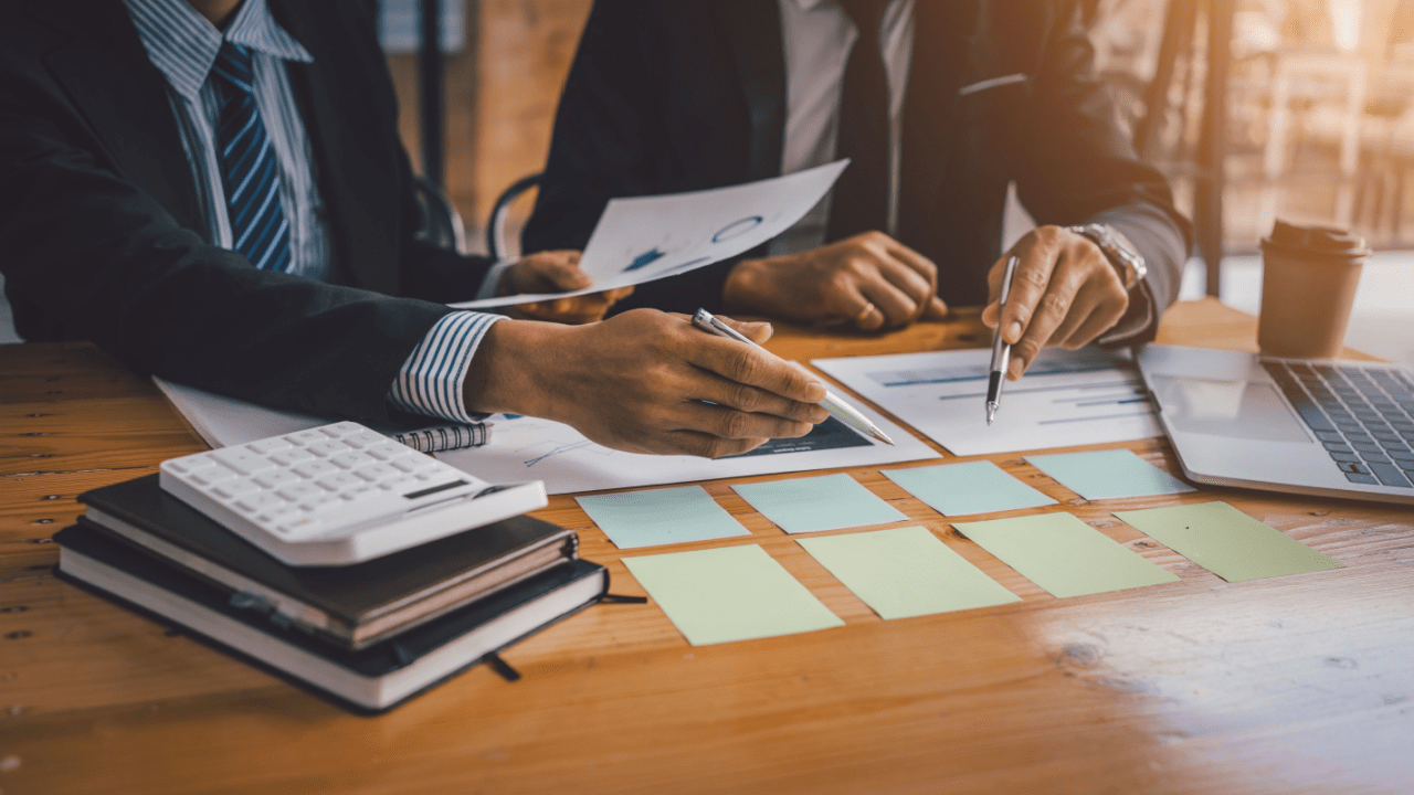 Tax professionals reviewing financial documents and charts showing how to get IRS to forgive tax debt strategies