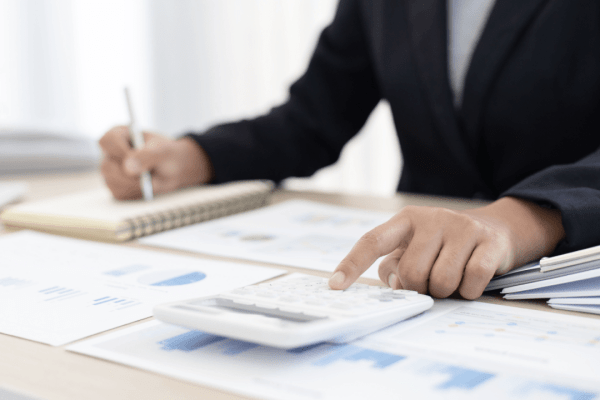 Professional calculating how much will the IRS usually settle for using calculator and financial documents