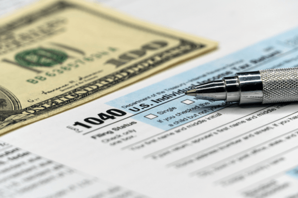 Is it better to settle a debt or go to court - tax forms with pen and money
