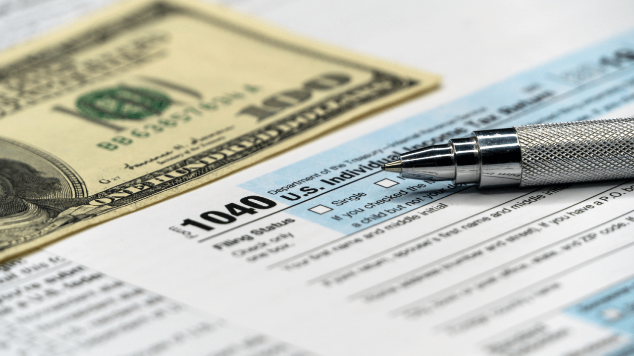 Is it better to settle a debt or go to court - tax forms with pen and money