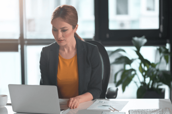 Professional woman reviewing tax advocate vs attorney costs compared documents at modern office desk