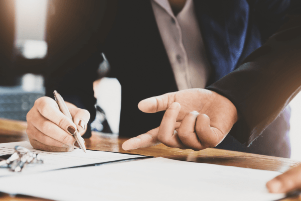 Professional CPA writing notes during tax consultation showing how can a CPA help with tax problems